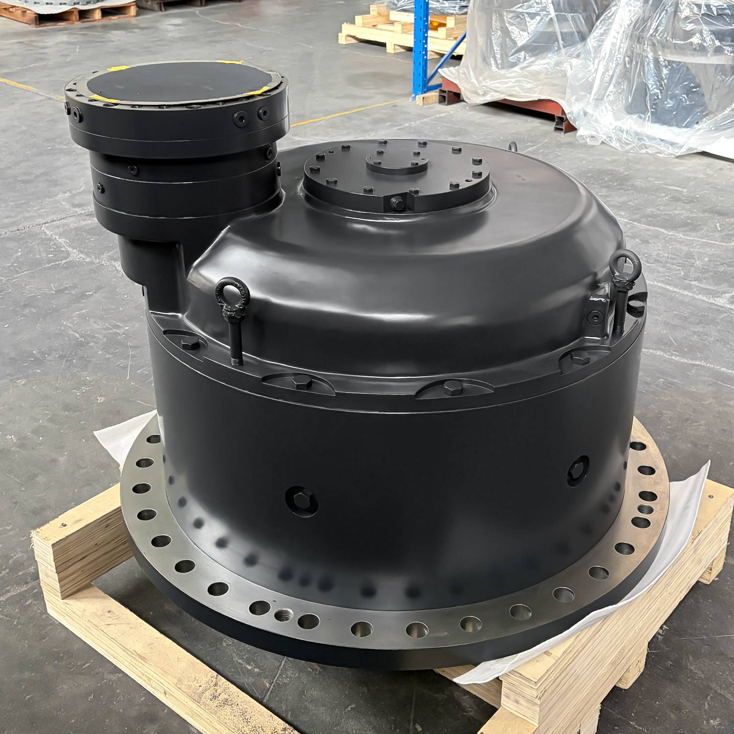 Brand-new travel gearbox assembly with hydraulic travel motor on top and sprocket mounting flange below, finished and ready to crate
